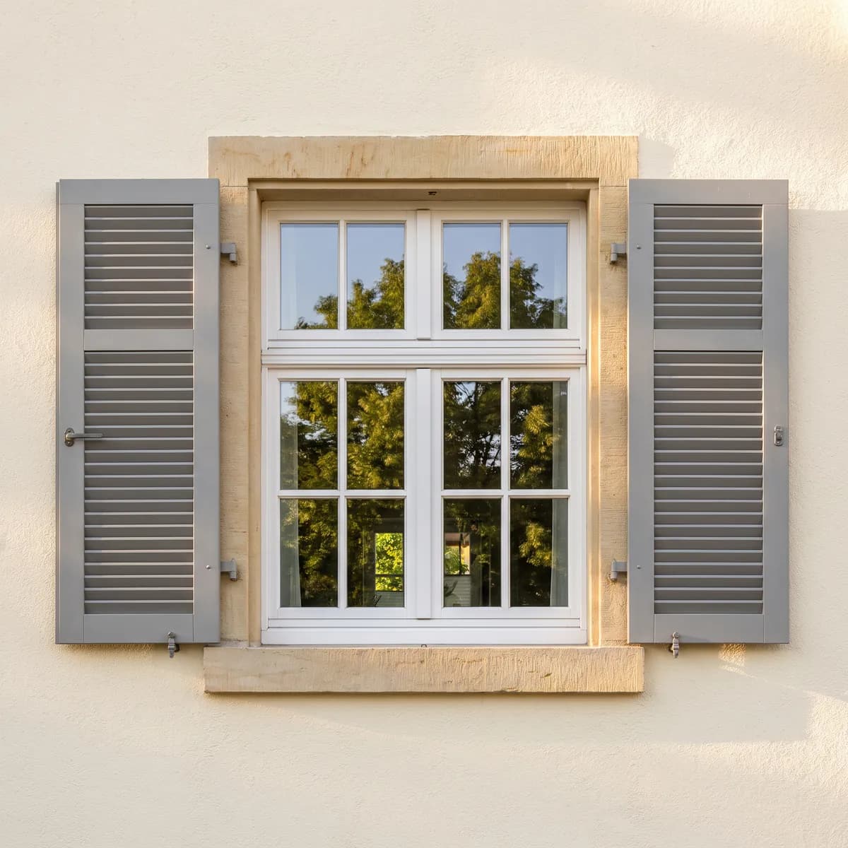 Sprossenfenster mit Klappläden und Sandsteingewände (KI-generiertes Symbolbild)